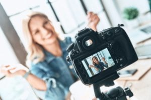 Filming. Beautiful young woman in casual wear smiling while recording video