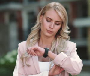 Woman looking at her watch to check Facebook post schedule.