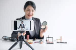 In this article that shares how to use video for marketing, this image shows a woman in front of a video camera filming herself. 