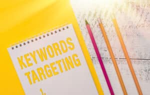 In this article that shares affordable marketing strategies, this image shows keyword targeting in bold letters with pencils and a bright light.